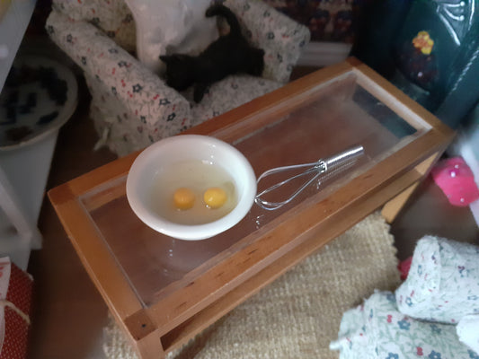 Bowl with eggs and a whisk